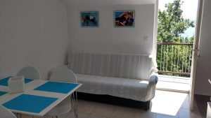 Kvarnersolutions: modern lakás belső tere, kék asztallapokkal és balkonos kilátással.